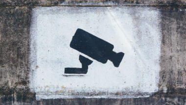 Die Schablone einer Überwachungskamera ist auf eine Wand gesprüht.