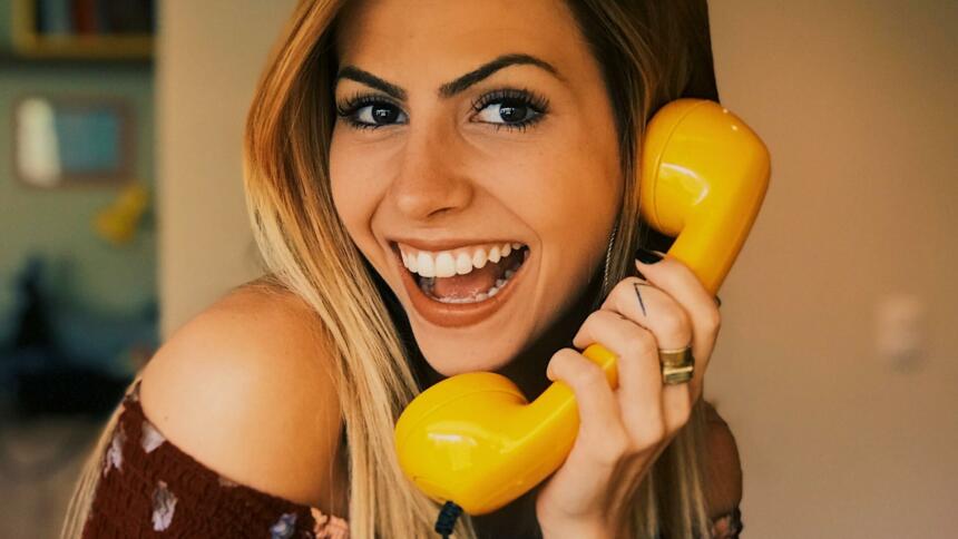 Frau an gelben Telefon