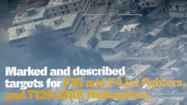 Auf dem Screenshot ist ein brennendes Haus zu sehen, davor in weiß und gelb die Schrift "Marked and described targets for F16 and F4 jet fighters, and T29 ATAK helicopters".