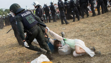 Polizist zerrt Frau über Boden