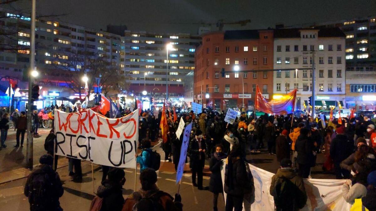 Demonstration, im Vordergrund ein Banner mit Aufschrift "Workers rise up"