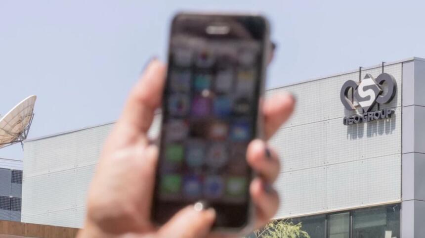 Handy wid hochgehalten vor NSO-Firmensitz