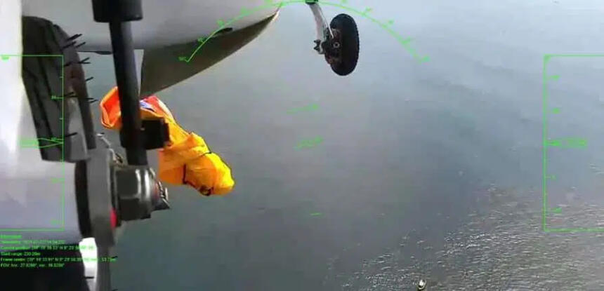 Das Bild zeigt das Fahrwerk einer Drohne, im hinteren Teil eine Rettungsinsel in der Farbe orange, die sich gerade entfaltet.