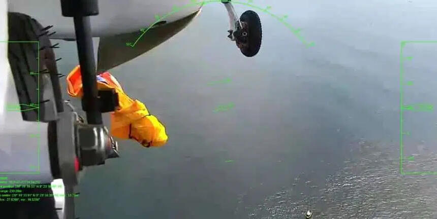 Das Bild zeigt das Fahrwerk einer Drohne, im hinteren Teil eine Rettungsinsel in der Farbe orange, die sich gerade entfaltet.