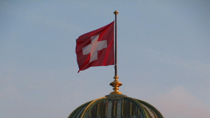 Kuppel des Schweizer Bundeshauses mit Flagge bei Sonnenuntergang