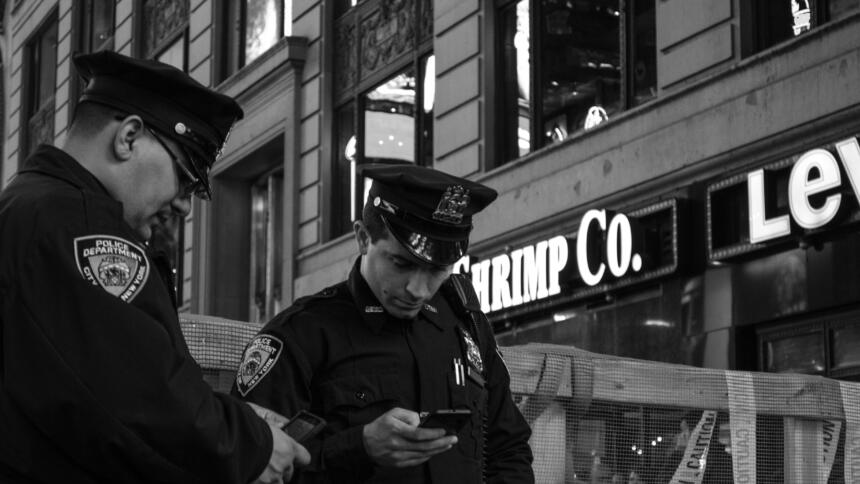 Zwei Polizisten gucken auf ein Handy