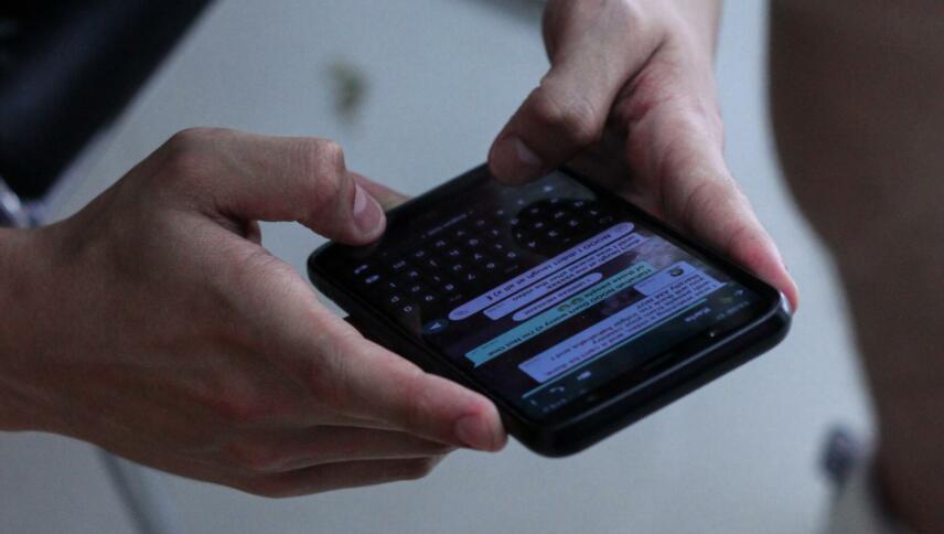 Zwei Hände tippen Nachricht in Chat