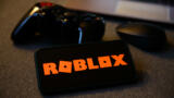 Smartphone mir Roblox Logo und Controller.