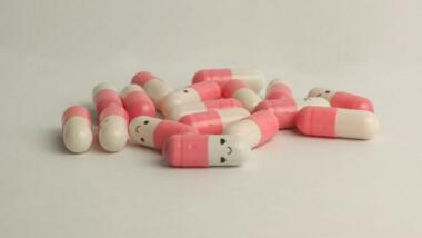 Pink-weiße Pillen mit aufgemaltem lächelnden Gesicht