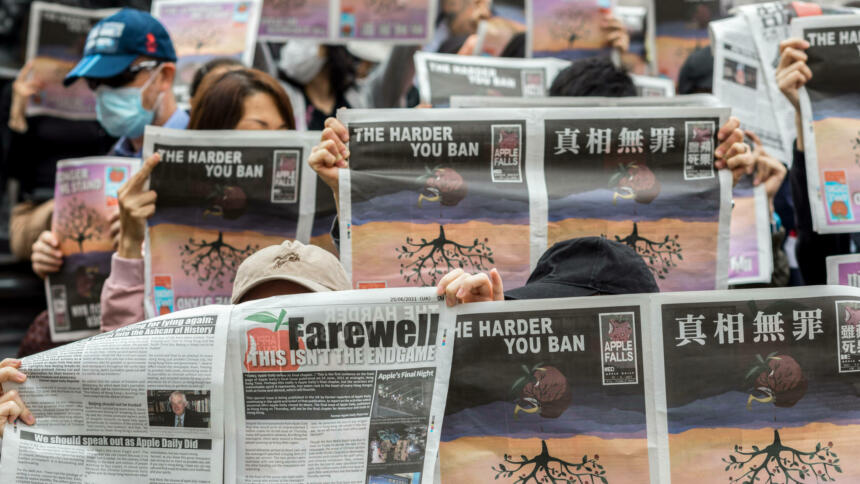 Protestierende halten eine Ausgabe der Zeitung Apple Daily hoch