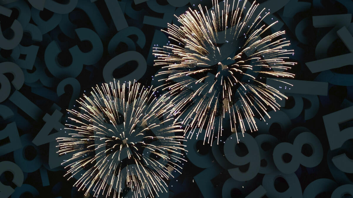 Hintergrund: Zahlen, Vordergrund: Feuerwerk