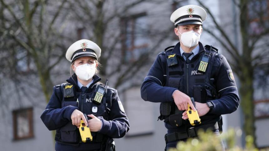 Das Bild zeigt eine Polizistin und einen Polizisten mit gezücktem Taser.