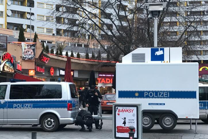 Das Bild zeigt wie Polizisten einen Anhänger mit der Aufschrift "Polizei" am Kottbusser Tor parken; aus diesem ist ein Teleskop mit einer Kamera ausgefahren.
