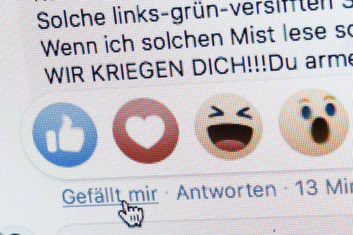 Ein fiktives Hassposting im Facebook-Stil. Enthält "Wir kriegen dich!", der Cursor zeigt auf "Gefällt mir"