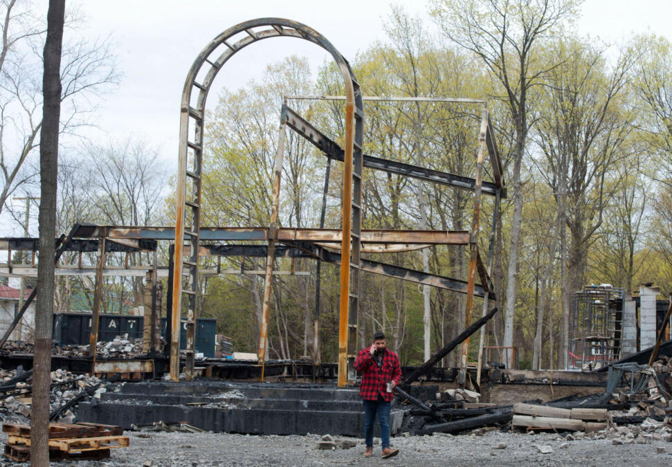 26. April 2021, Montreal, Kanada: Menschen blicken auf den Schauplatz eines Feuers, das eine 19,5 Millionen Dollar teure Villa zerstört hat, die für Mindgeek, die Muttergesellschaft von Pornhub, gebaut wurde. 