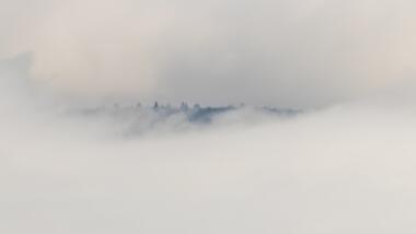 Berge schauen aus Nebel heraus