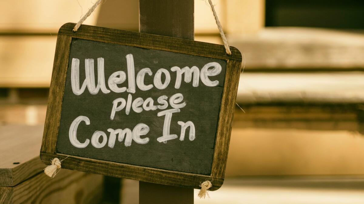 Schild mit Aufschrift "Welcome, please come in"