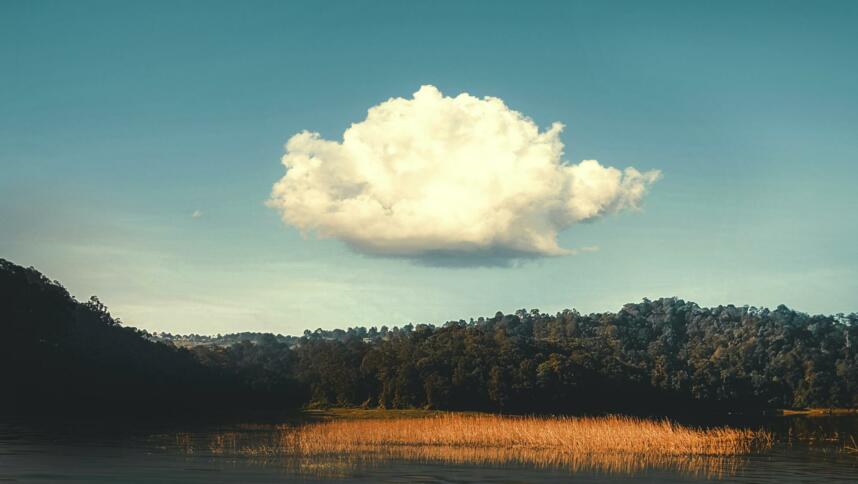 Eine weiße Wolke über einer Wasserfläche