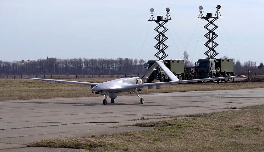 Das Bild zeigt eine Drohne "TB2" auf einem Rollfeld or Lastwagen mit Antennen.