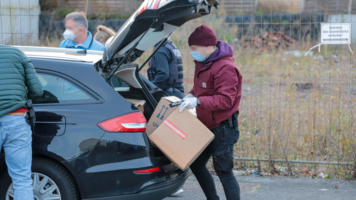 Polizisten laden Kartons in ein Auto