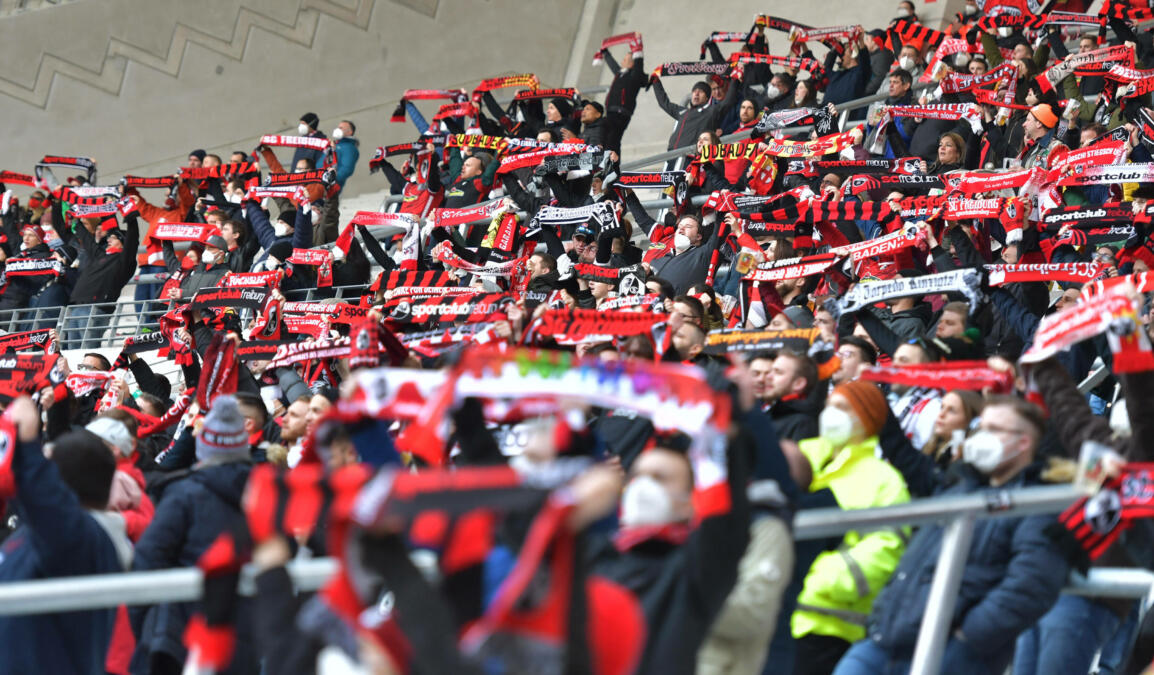 Fußballfans halten Schals nach oben