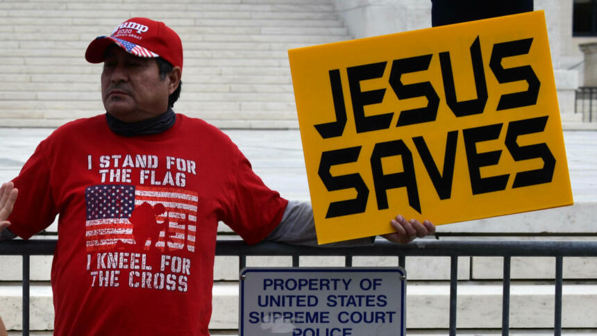 Ein Mann hält ein Schild mit der Aufschrift "Jesus Saves"