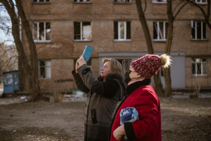 Zivilist:innen dokumentieren Kriegsschäden in Kiew.