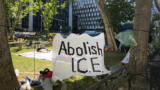 Ein Protestcamp vor dem ICE-Gebäude, im VOrdergrund ein Banner mit der Aufschrift "Abolish ICE".