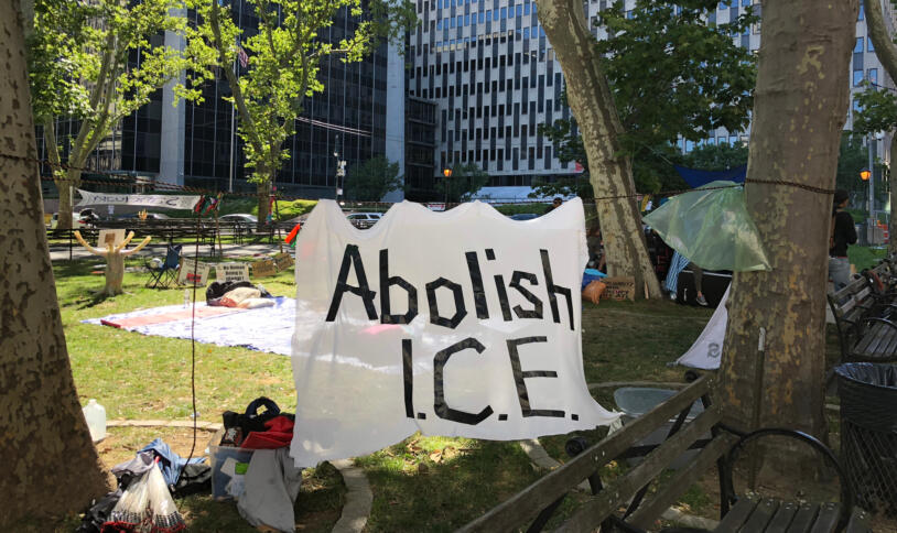 Ein Protestcamp vor dem ICE-Gebäude, im VOrdergrund ein Banner mit der Aufschrift "Abolish ICE".