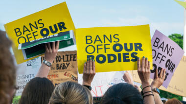 Menschen halten auf einer Demonstrationen Plakate mit der Aufschrift "Bans off our bodies" hoch.