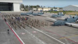 Ein Rollfeld mit 5 Global Hawk, davor stehen mehrere Dutzend Soldat:innen stramm, im Hintergrund ein Hangar.