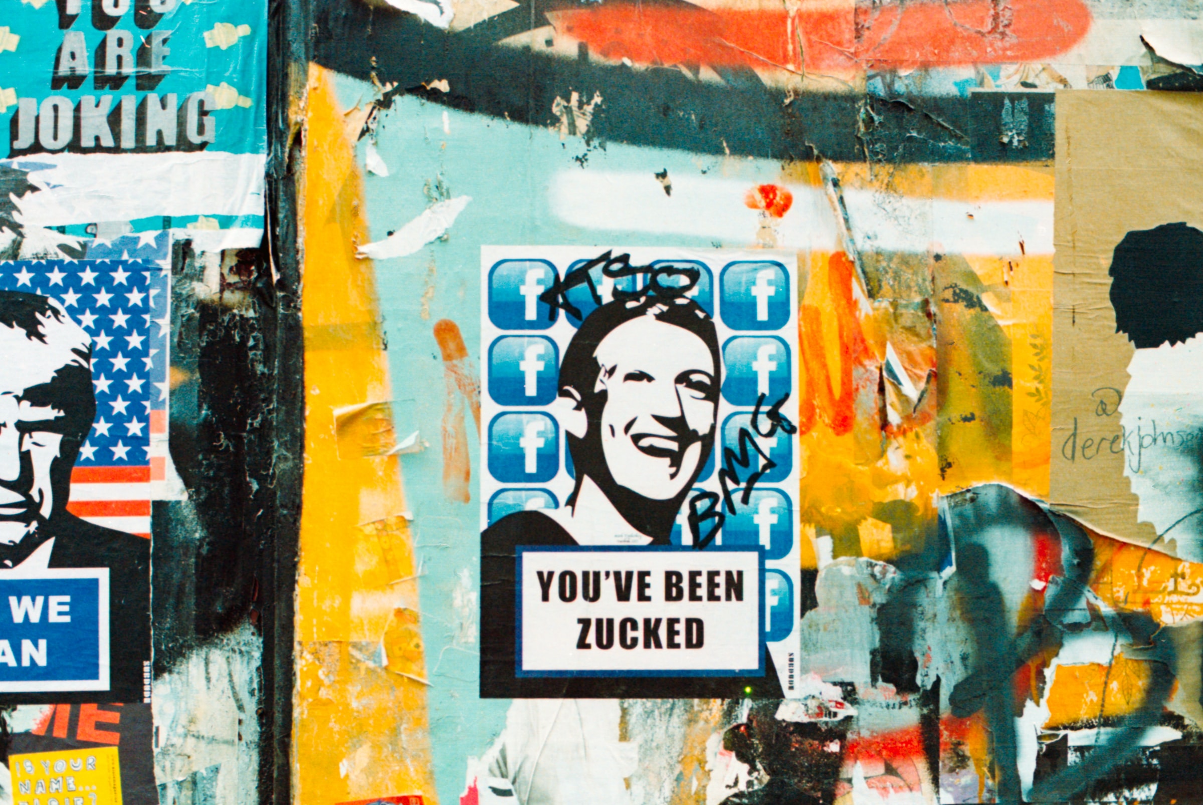Eine mit Graffiti bemalte Wand ist zu sehen. Im Mittelpunkt der Wand ist ein schwarz-weiß Bild von Zuckerberg. Daneben mehrere Abbildungen des Facebook "F" Symbols. Unter der Abbildung Zuckerbergs steht "YOU'VE BEEN ZUCKED".
