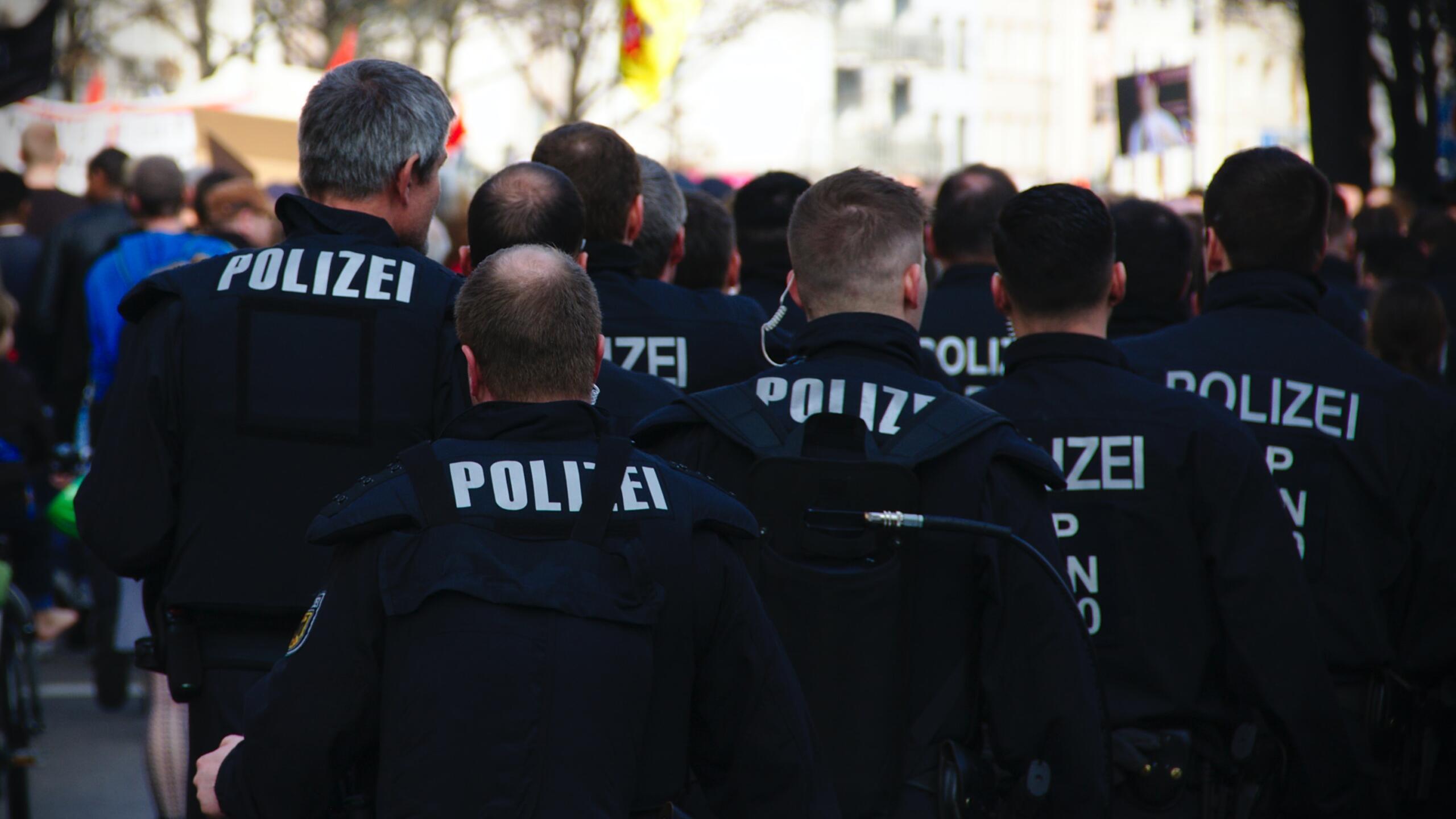 Eine Gruppe Polizisten, die man von hinten laufen sieht
