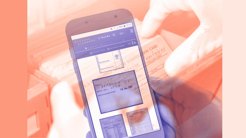 Im Hintergrund sind Karteikarten der NS-Bürokratie, im Vordergrund ein Handy, das ein solches digitalisiertes Dokument zeigt.