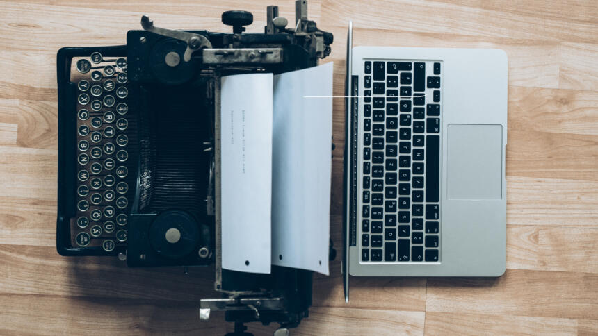 Eine Schreibmaschine steht einem Laptop gegenüber.