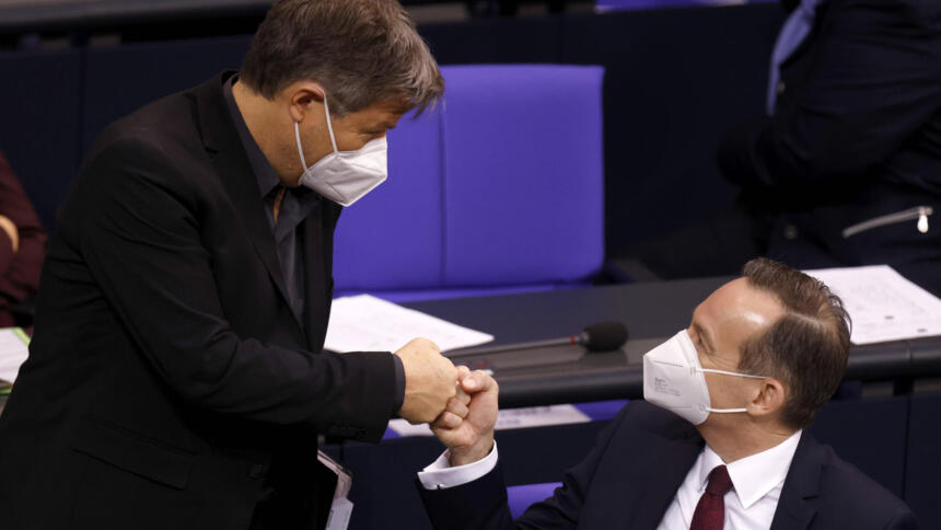 Zwei Männer in Anzügen, die sich im Bundestag einen Fist-Bump geben