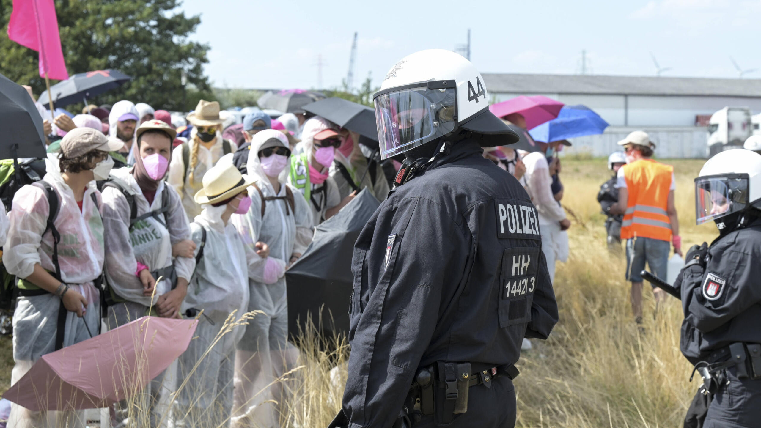 Polizist steht einer Gruppe Demonstrierenden gegenüber