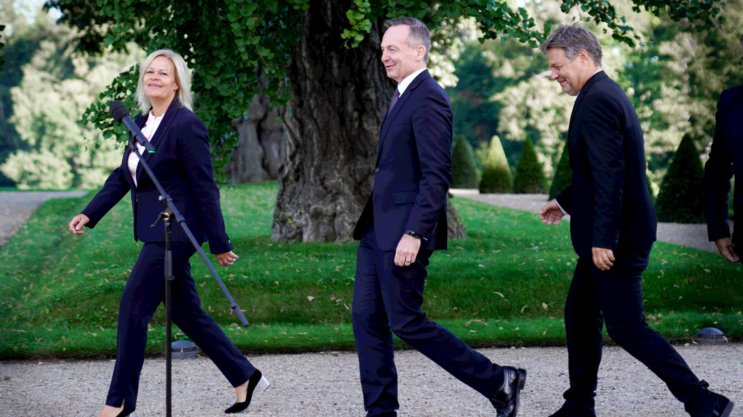 Bundesinnenministerin Nancy Faeser (SPD), Bundesverkehrsminister Volker Wissing (FDP) und Wirtschafts- und Klimaminister Robert Habeck (Gruene) schreiten auf der Kabinettsklausur in Schloss Meseberg zu den Mikrofonen.