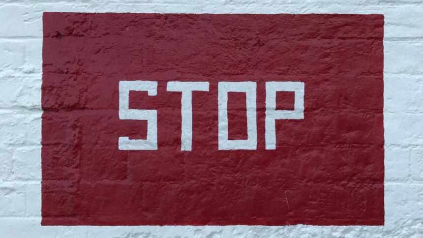 "Stop" auf eine weiße Backsteinwand geschrieben