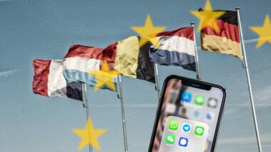 Flaggen europäischer Länder mit Smartphone im Vordergrund, auf dem Messenger-Dienste angezeigt werden