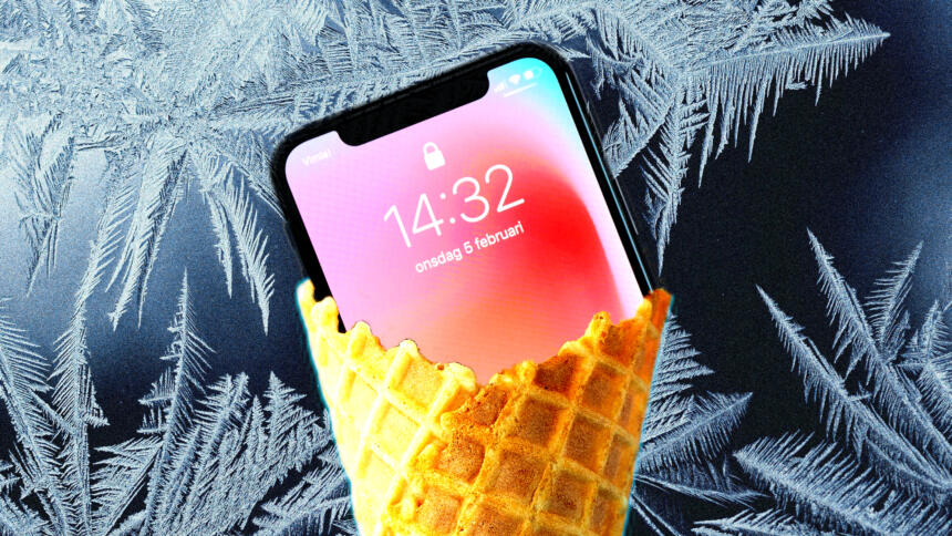 Eine Eiswaffel, in der ein Handy steckt vor Eisblumenhintergrund