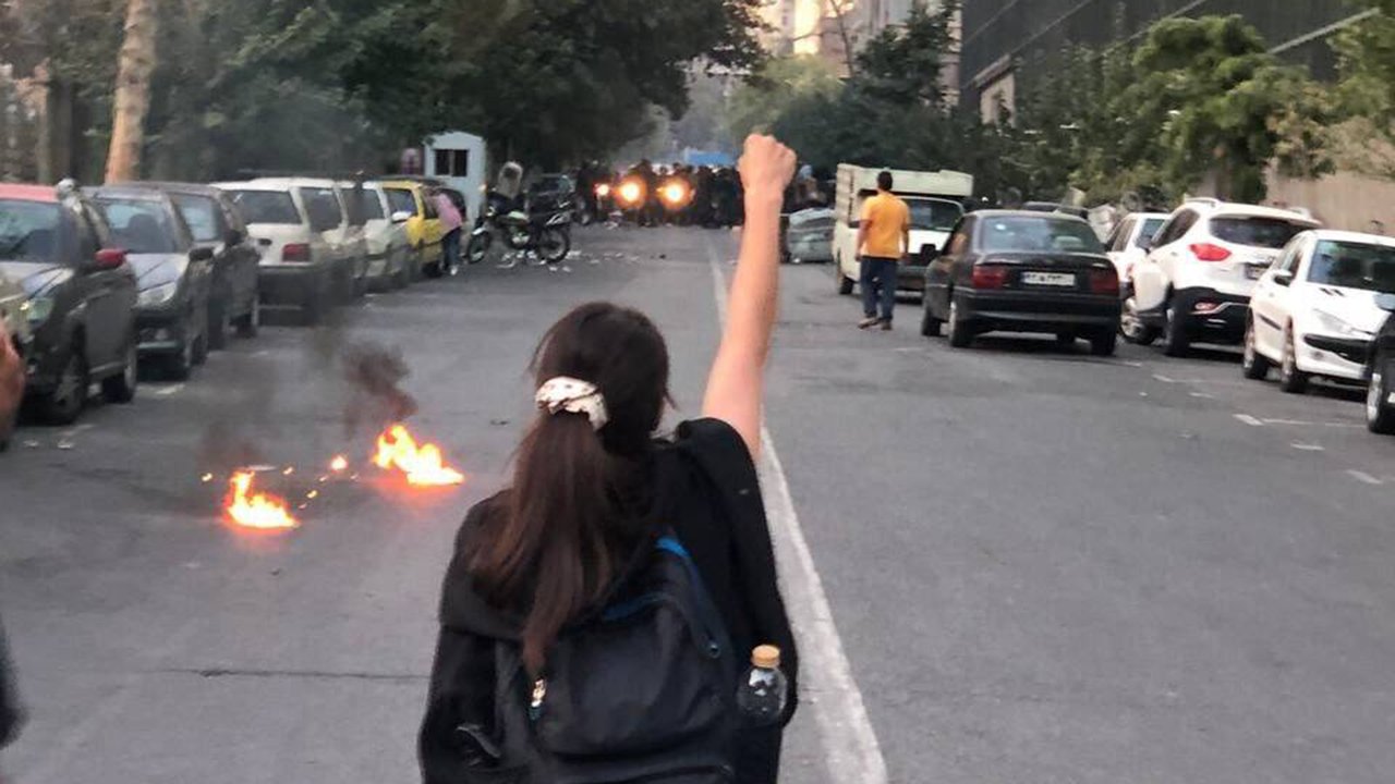 Frau reckt die Faust auf der Straße gegen Polizeikräfte