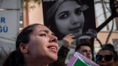 Protestierende Menschen mit einem Plakat im Hintergrund, auf dem das Gesicht von Asra Panahi abgebildet ist