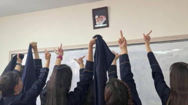 Schülerinnen zeigen Bild von Khomeini und Chamenei den Stinkefinger