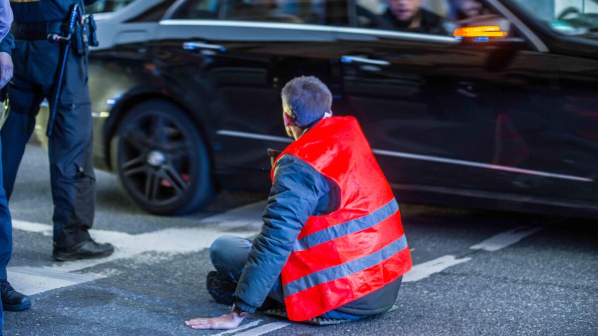 Ein Aktivist der Letzten Generation hat sich auf einer Straße in München festgeklebt.
