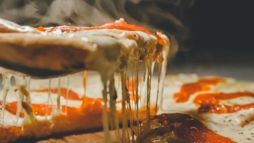 Käse bildet Fäden auf einer Pizza