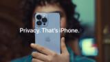 Eine Person mit kurzen, schwarzen lockigen Haaren in blauem Hemd hält ein graues iPhone in die Kamera. Davor der Schriftzug: "Privacy. That's iPhone."