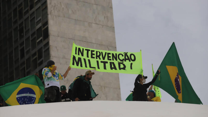 Faschistische Besetzer:innen in der Hauptstadt Brasilia halten ein Plakat mit der Forderung nach einem Militärputsch.