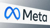 Meta-Logo vor grauem Hintergrund, an den Schlaufen des Logos sind Nippel.