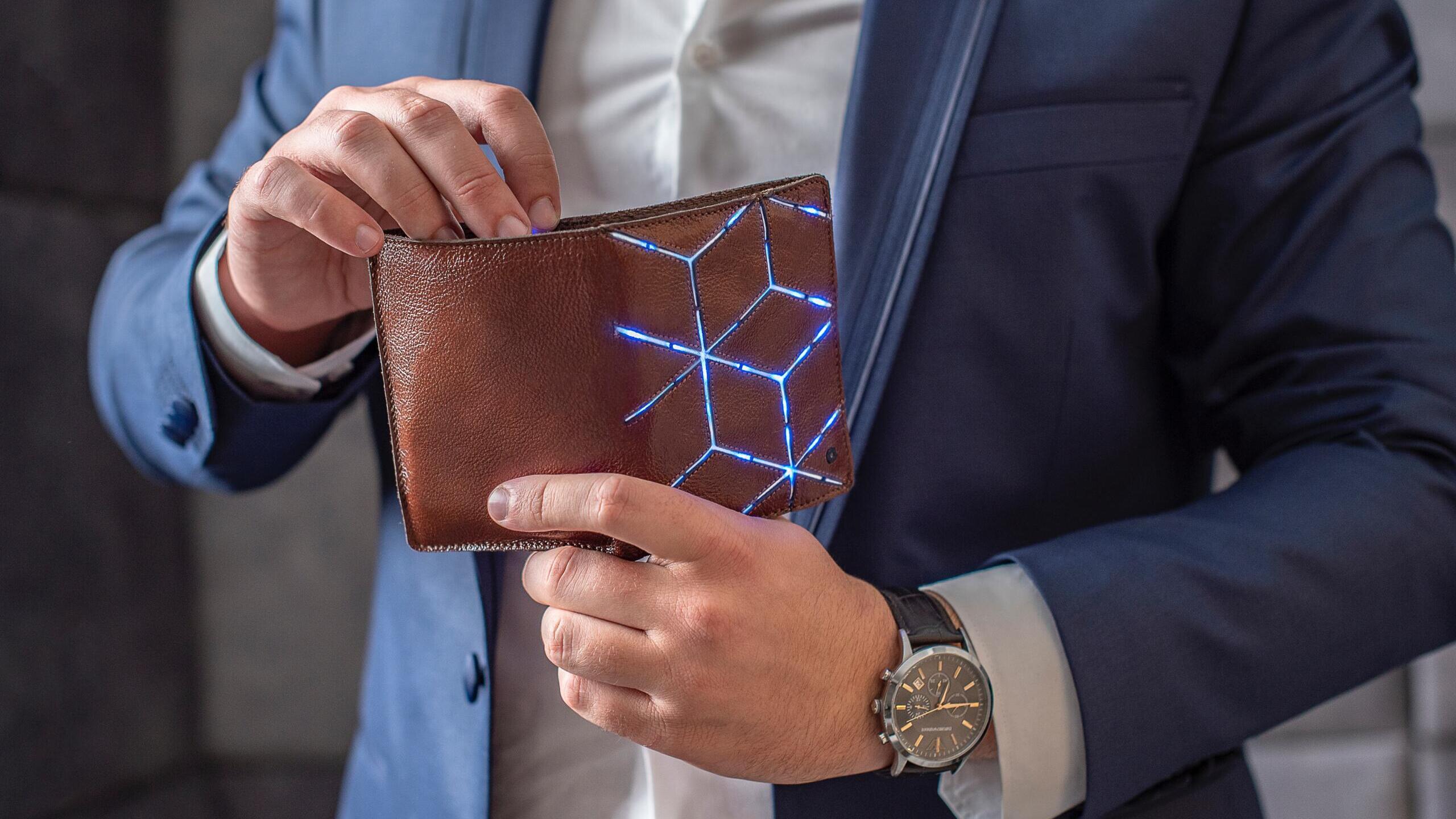 Mann hält Geldbeutel in der Hand, der leuchtet